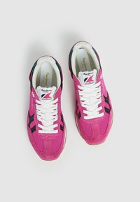 Paire de baskets roses Pepe Jeans London avec des lacets blancs, des accents noirs sur les côtés et des semelles beiges sur un fond clair uni.