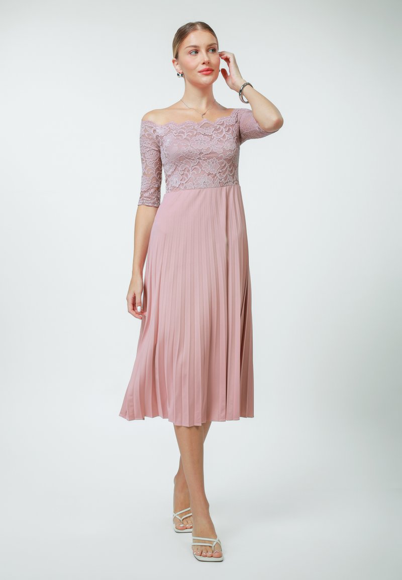 Off-the-shoulder dress in light pink featuring a lace bodice and pleated skirt, crafted from soft fabric with a flowing silhouette.
