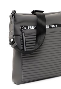 Borsa a tracolla grigia a coste con tracolla nera regolabile e tasca frontale con zip, caratterizzata da testo bianco "FREY" su striscia nera.