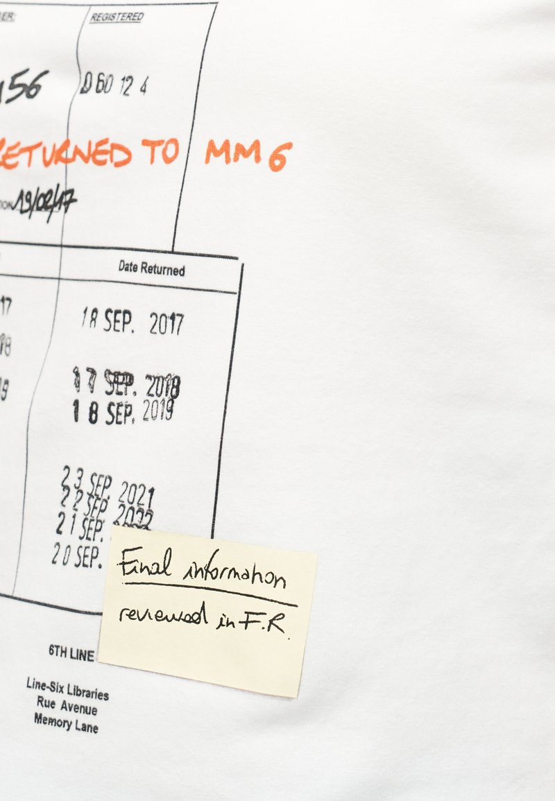 Dates écrites à la main et tamponnées sur une feuille blanche, avec un texte orange disant « RETOURNÉ À MM6 » et un post-it indiquant « Informations finales vérifiées en F.R. »