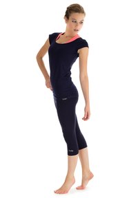 Jūras spēku sporta tops ar rozā apkakli, saskaņots ar jūras spēku kapri legingiem. Audums izskatās gluds un pieguļošs, uz legingiem ir neliela zīmola logo.