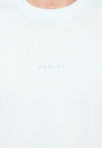 Ανοιχτό μπλε βαμβακερό t-shirt με ραμμένο λαιμό και ανάγλυφο λογότυπο "OAKLEY" σε ταιριαστό ανοιχτό μπλε στο στήθος.