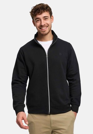 Svart hettegenser med glidelås laget av mykt stoff med høy krage, med en diskret logo på brystet og elastiske mansjetter og kant.