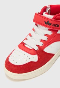 Baskets montantes rouges et blanches avec un dessus en daim et synthétique, bout perforé et sangle de cheville ajustable avec détail de logo.