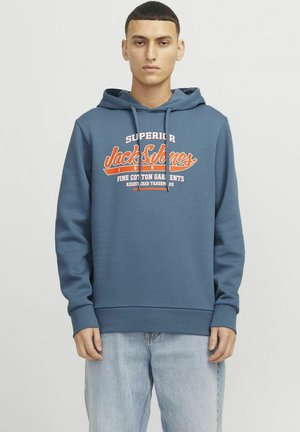 Blue cotton hoodie with a front pocket, drawstring hood, and a large, contrasting white and orange logo. Fitted cuffs and hem.