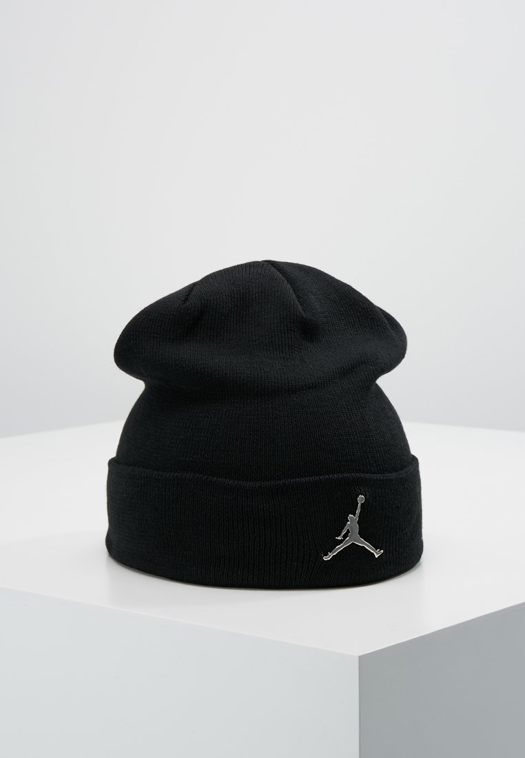 Musta neulepipo pehmeällä pinnalla, jossa on käännettävä reunus ja hopeinen Jumpman-logo edessä. Klassinen muotoilu ja yksinkertainen malli.