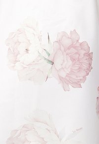 Delikatne różowe i białe kwiaty piwonii z zielonymi liśćmi nadrukowane na białym materiale, z małym napisem "Le Brate" w pobliżu kwiatów.