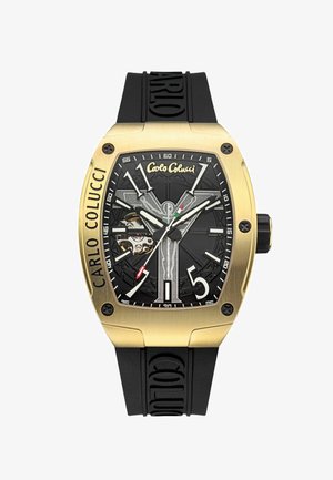 Black dial watch with gold stainless steel case, large black rubber strap. Features bold silver and white hour markers, skeleton movement visible.