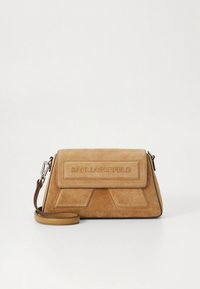 Barna velúr kézitáska szögletes kialakítással, fedelénél patenttal, dombornyomott márkanévvel és levehető vállpánttal. Texturált felület kontrasztos díszítésekkel.