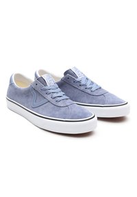 Paire de baskets Vans en daim bleu clair avec semelles en caoutchouc blanches, lacets bleus et logo « Off The Wall » sur la languette, inclinées vers la droite sur fond blanc.