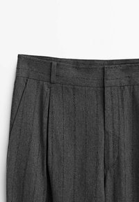 I pantaloni grigi su misura presentano un taglio dritto, righe verticali e una vita piatta con pieghe sottili per un tocco di dettaglio.