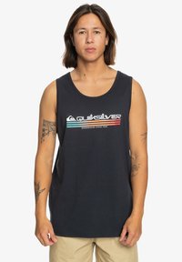 T-paita ilman hihoja, tummansinistä puuvillaa, jossa on valkoinen, sininen ja punainen Quiksilver-logo. siinä on pyöreä kaula-aukko, eikä muussa ole koristeita.