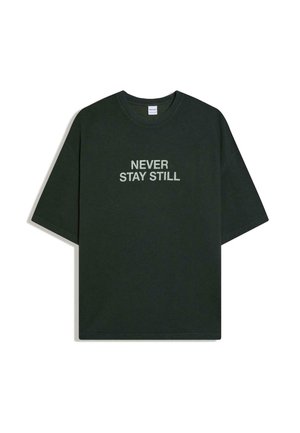 Tmavozelené tričko s krátkym rukávom a okrúhlym výstrihom, na prednej strane v strede biely nápis "NEVER STAY STILL".