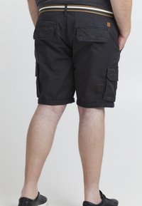 Svarte cargo-shorts med flere sidelommer, rullet kant og en kontrasterende stripete midjebånd. Laget av slitesterkt stoff med matt finish.