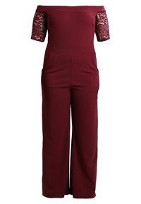 Bordeauxroter Jumpsuit mit schulterfreiem Ausschnitt und kurzen Spitzärmeln, ausgestattet mit zwei Fronttaschen und einem taillierten Oberteil, das in weit geschnittene Hosen übergeht.