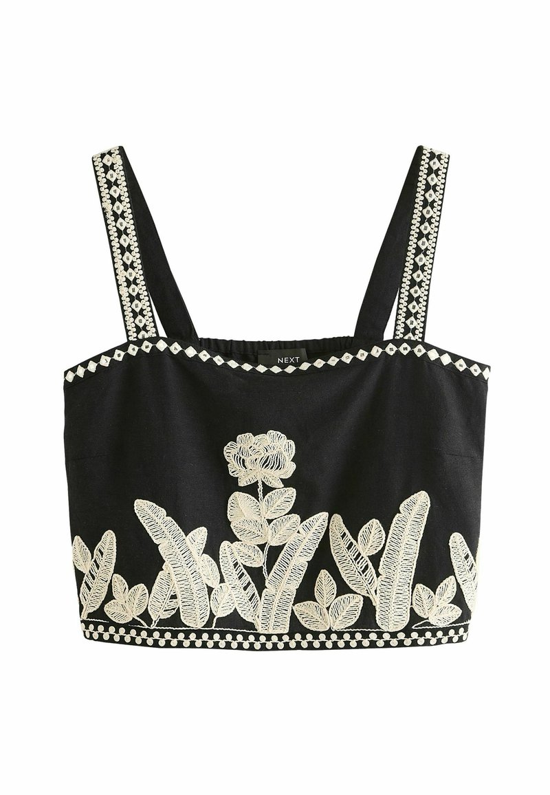 Top corto negro con bordados florales blancos y acentos geométricos. Presenta tirantes anchos y una tela texturizada.
