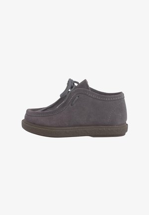 Scarpa in suede grigia con punta tonda, lacci sulla parte superiore e suola in gomma con texture. Presenta dettagli di cucitura lungo i bordi.
