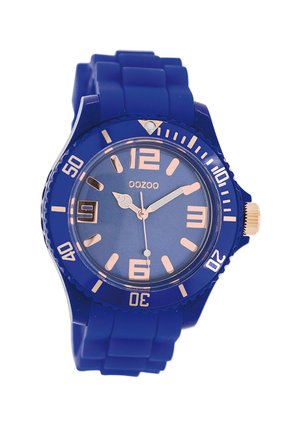 Montre en silicone bleue avec un cadran circulaire, index et aiguilles en rose gold, dotée d'un guichet de date à 3 heures et d'une lunette texturée.