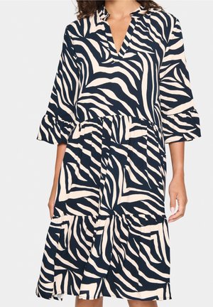 Marineblaue und cremefarbene Zebramuster-Kleid mit V-Ausschnitt, dreiviertel Ärmeln und einem gestuften Rock. Hergestellt aus leichtem Stoff mit weicher Textur.