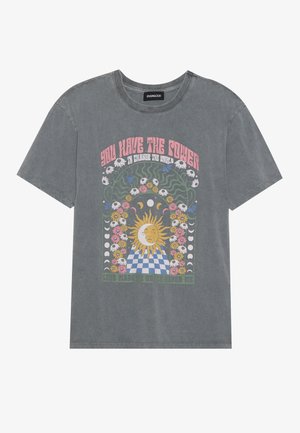 T-shirt en coton gris présentant un design graphique coloré avec un soleil, des fleurs et des motifs à carreaux. Manches courtes et coupe décontractée.