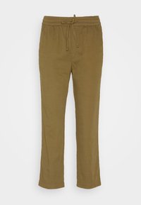 Pantalons stretch beige avec une taille élastique et un cordon de serrage. Coupe droite, tissu léger et design simple. Pas de poches visibles.