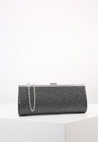 Pochette nera glitter con forma rettangolare, tracolla in catena argentata, chiusura metallica liscia e superficie testurizzata.