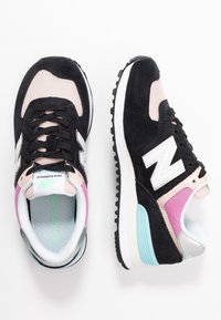 Baskets noires en suede et en mesh avec des accents rose pâle, détail du logo blanc, talon gris et semelle intermédiaire teal, dotées de lacets noirs et d'une semelle extérieure texturée.