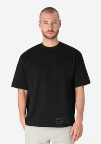 Black short-sleeve t-shirt crafted from soft fabric, featuring a crew neck and a relaxed fit, with minimal branding near the hem.