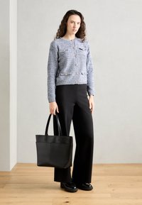 Blue textured cardigan with gold buttons, black wide-leg pants, and a black tote bag. Smooth fabric, fitted shape, minimalistic design.