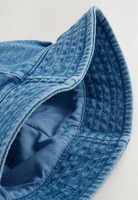 Denim-Bucket-Hut in verschiedenen Blautönen mit einer strukturierten Außenschicht und einem glatten Innenfutter. Verfügt über einen breiten, genähten Rand.