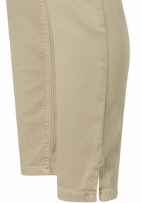 Pantalones cortos caqui hechos de una mezcla de algodón; presentan detalles de costura y aberturas laterales cerca del dobladillo para mayor comodidad y rango de movimiento.