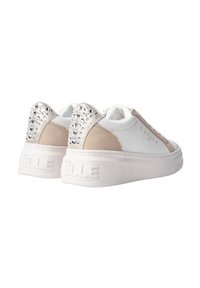 Sneaker bianchi e beige con una suola texturizzata, dettagli in suede e un tacco adornato di strass. Marchio visibile sul lato.