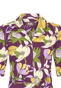 Lyhythihainen, violetti mekko, jossa on keltainen, vihreä ja laventelinvärinen kukkakuosi. Varustettu kauluksella, napeilla ja yhteensopivalla vyöllä.