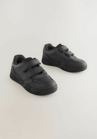 Schwarze Sportschuhe mit einer strukturierten Gummisohle, zwei verstellbaren Klettverschlüssen und einem glatten synthetischen Obermaterial mit minimalem Design.