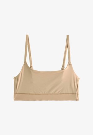 Beež sujuhe crop top, kus on õhukesed reguleeritavad õlavarre rihmad, valmistatud sujuvast venivast kangast, asetatud tasasele valgele taustale.