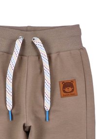 Bruine sweatpants met ribgebreide tailleband, voorzien van een rechthoekig logo met een beer en de tekst "Sweet Bear", en een multicolore trekkoord.