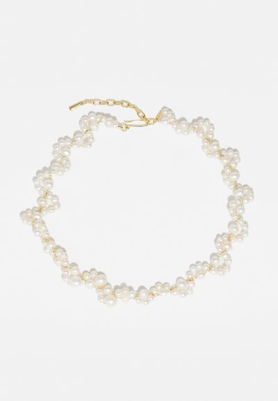 Κολιέ από πέρλες με ομάδες λευκών πετρών διαφόρων μεγεθών, χρυσές μεταλλικές αλυσίδες και κλείσιμο αλυσίδας. Λείος, γυαλιστερός υφή, λεπτός σχεδιασμός.