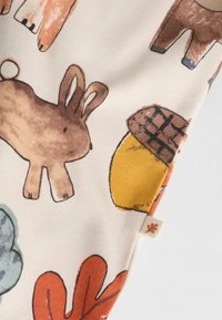 Stoff mit verspielten Tier- und Naturmotiven, darunter ein Kaninchen, eine Eichel und bunte Blätter. Weiche Textur auf hellem Hintergrund.