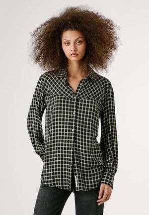 Camicia a quadri nera e verde con chiusura a bottoni, due tasche sul petto, colletto e maniche lunghe con polsini abbottonati.