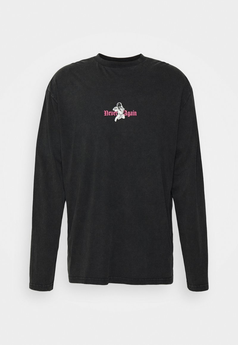 Chemise noire à manches longues avec un petit graphique blanc d'astronaute et un texte rose "Never Again" centré sur la poitrine.