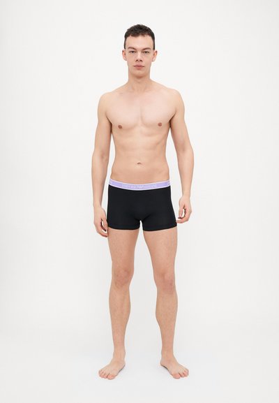 Boxers negros con una cinturilla elástica de lavanda claro que presenta la impresión "EMPORIO ARMANI". Tela suave, diseño ajustado, longitud hasta medio muslo.