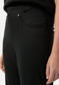 Zwarte broek met een gladde textuur, een slank figuur, zakken aan de voorkant met een subtiele metalen accent en een nette taillebandontwerp.