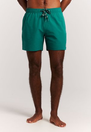 Turkooizen zwemshorts met een gestructureerde afwerking, elastische tailleband en verstelbaar trekkoord. Voorzien van een logo aan de linkerkant.