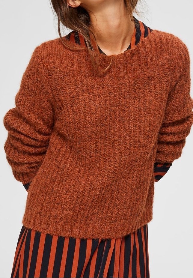 Maglione a maglia color ruggine con finitura testurizzata, dotato di scollo rotondo e maniche oversize, abbinato a uno strato sottostante a righe.