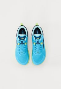 Baskets de sport bleues avec une tige en mesh, des accents vert lime et une semelle flexible. Des détails réfléchissants et un système de laçage améliorent la fonctionnalité.
