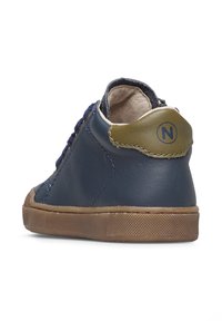 Sneaker in pelle blu navy con accenti testurizzati verde oliva, punta tonda e suola in gomma marrone. Design con lacci e dettagli di cucitura a contrasto.