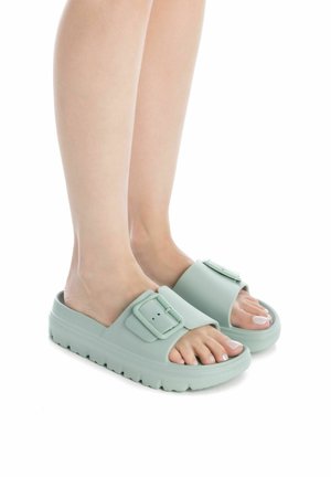 Ciabatte in gomma verde chiaro con fibbia regolabile, suola texturizzata, design a fascia larga e punta arrotondata. Ideali per un uso casual.