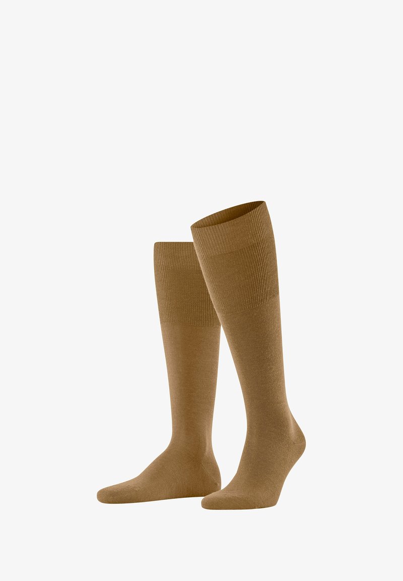 Calze al ginocchio di un caldo colore marrone, realizzate in un materiale morbido con una texture a coste e una banda superiore liscia.