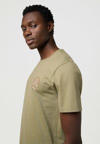 Wrangler SHORT SLEEVE SMALL GRAPHIC TEE - REGULAR FIT - Camiseta estampada - aloe