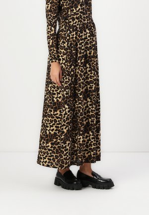 Maxikjole med leopardmønster, lange ermer og elastisk midje. Kombinert med svarte kraftige loafers med tykk såle og glatt finish.